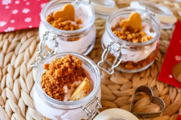 Söta små glasburkar med rosa kräm, smulad kaka och hjärtformade kex. Ett perfekt mjukglass recept utan glassmaskin för alla hjärtans dag.